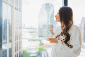 Portrait beautiful young asian woman hold coffee cup with city view