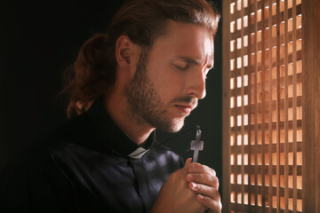 Male priest in confession booth