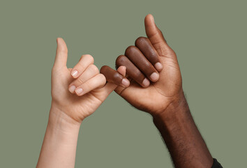 Hands of Caucasian woman and African-American man on color background. Racism concept
