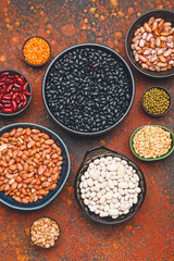 Different raw legumes on color background