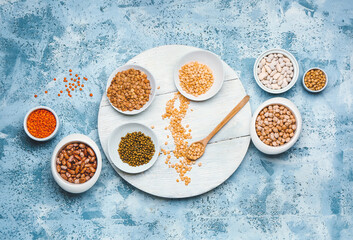 Different raw legumes on color background