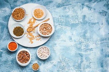 Different raw legumes on color background