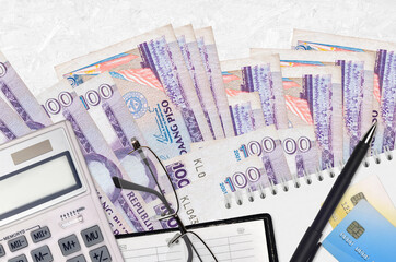 100 Philippine piso bills and calculator with glasses and pen. Tax payment concept or investment solutions. Financial planning or accountant paperwork