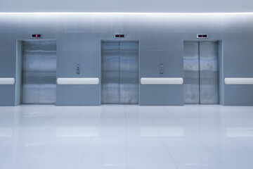 Three   Modern passenger or cargo elevators in hotel  or hospital and white floor
