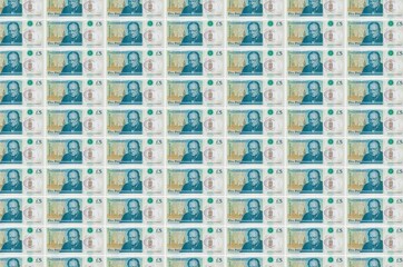 5 British pounds bills printed in money production conveyor. Collage of many bills. Concept of...