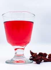 A cup of pink rosella tea with dried rosella