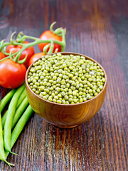Mung beans  in bowl with vegetables on dark wooden board