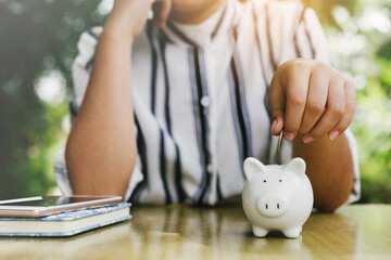 Hand putting coin on pig saving. business, investment, retirement, finance and Money Saving for the...