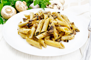 Pasta with mushrooms in white plate on board