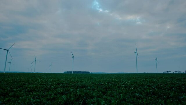 Windmills overlooking beautiful green farmland in Zlotoryja, Poland - time lapse