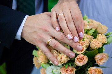Obraz na płótnie Canvas Hands and rings on wedding bouquet
