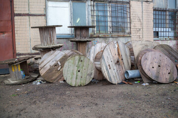 Empty coils from a high-voltage cable lie on a dump.