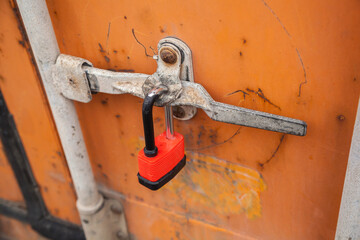 Close-up of closed cargo container on lock, sealed container in warehouse area.