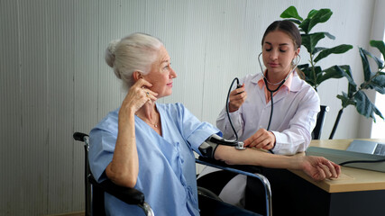 Positive minded doctor taking care of elderly woman at hospital, women doctor and elderly patient