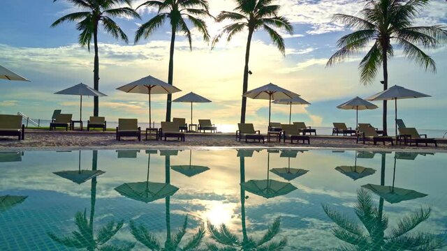 Umbrella and chair around swimming pool in resort hotel for leisure travel and vacation neary sea ocean beach at sunset or sunrise time