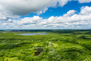Obraz premium Aerial view of a rural area and lake in the middle of a forest