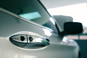 door handle of modern car parked at parking lot of condominium with bonnet or hood open, ready to be checked or fixed, push button to lock vehicle, keyless entry door handle, selective focus