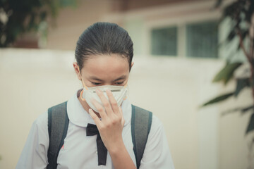 Portrait of Asian young girl in a school uniform wearing a mask N95
