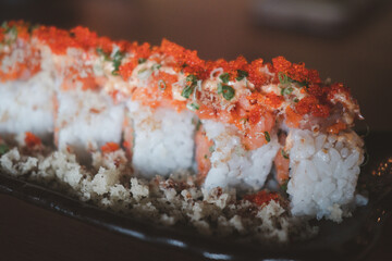 California roll topped with fresh salmon and salmon roe. Selective focus