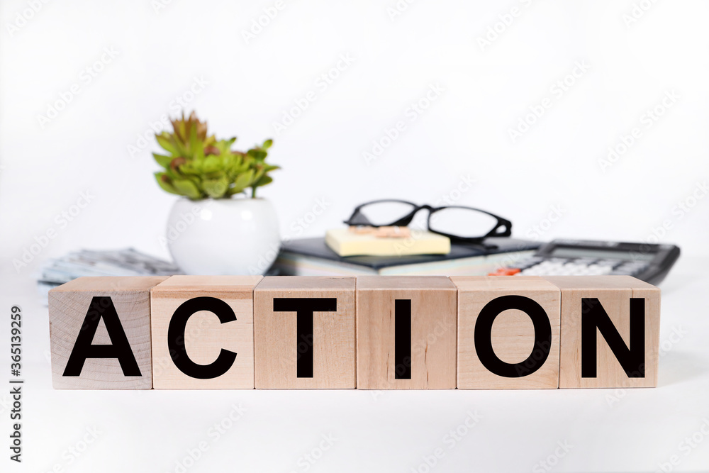 Wall mural action the word on wooden cubes, cubes stand on a reflective surface.business and finance concept