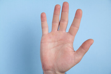 Male hand on blue background.
