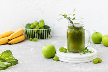 Green vitamin smoothie with shoots of young peas. Green smoothie made from apple, grape and kiwi
