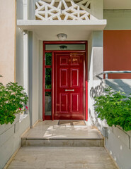 elegant family house entrance with dark red door and plants, Athens Greece