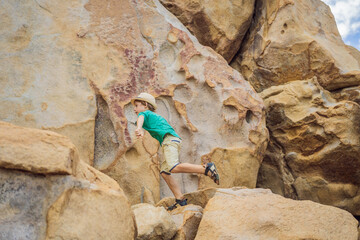 Young boy climbing on a rock, vacation concept