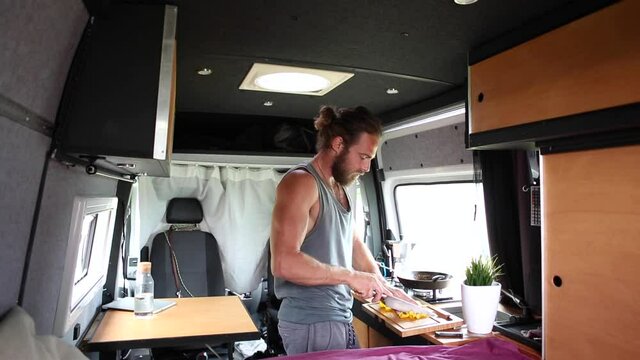 Man cooking inside his camper van
