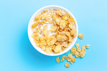 Plate with breakfast cereal on blue background, top view