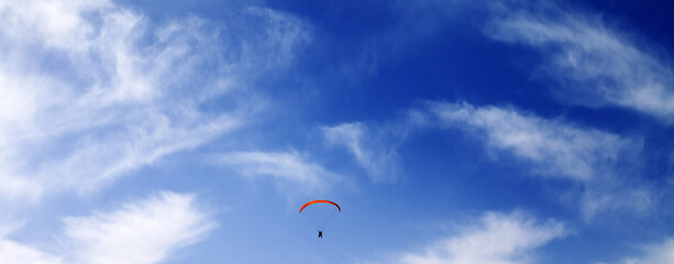 Silhouette of skydiver at sky