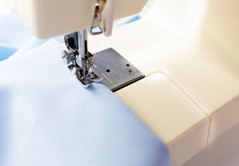 Sewing machine. Manufacture of wearing apparel. Blue fabric.