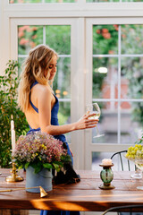 girl in blue dress standing with glass of wine.
