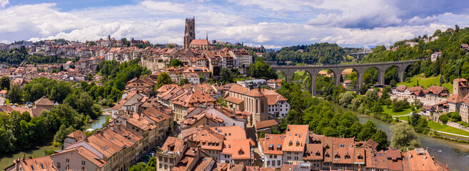 Aerial views of the rooftops, landmarks, river and bridges of the old town of Fribourg in...