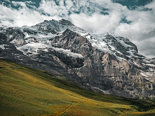Panoramic shot of the harsh rock textures and stunning alpine glacier landscape of the Jungfrau region of Swiss Alps.