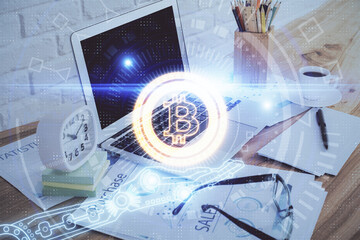 Double exposure of blockchain and crypto economy theme hologram and table with computer background. Concept of bitcoin cryptocurrency.