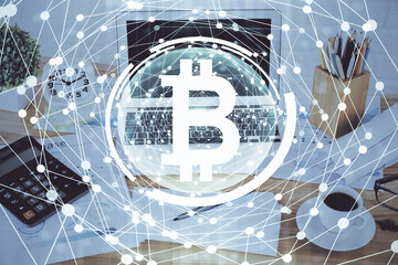 Double exposure of blockchain and crypto economy theme hologram and table with computer background. Concept of bitcoin cryptocurrency.