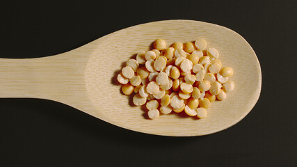 TOP VIEW: Yellow peas appear in wooden spoon
