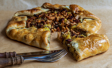 A cut piece of freshly baked open pie made from mushrooms golden chanterelles and potatoes.