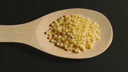 TOP VIEW: Couscous appears in wooden spoon