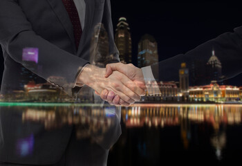 Teamwork, partnership and success concept. Double exposure of business handshake for successful of investment deal and city night background.