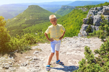 fearless adorable little happy boy stand on steep edge of limestone plateau overlooking the valley