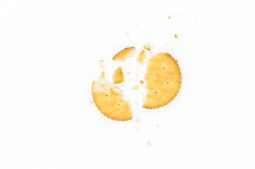 Cracker with pieces and crumbs on white background.