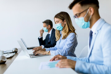 Group of business people have a meeting and working in office and wear masks as protection from corona virus - obrazy, fototapety, plakaty