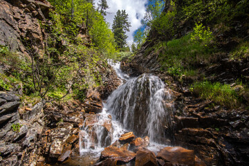 Waterfall on a mountain stream in the Siberian taiga