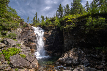 Naklejka na ściany i meble Waterfall on the Podkomarnaya River in the Khamar-Daban Mountains