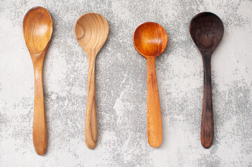 assorted wooden spoons on a grey background.