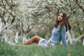 girl in a blooming garden in a blue jacket