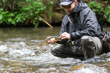 The fisherman carefully releases the fish back into the water