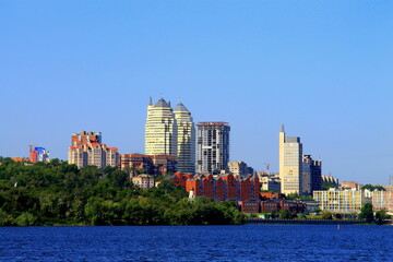Sunny summer, spring morning on the Dnieper river, view of the Monastery Island, buildings and white skyscrapers of Dnipro city, landscape. Dnepropetrovsk, Ukraine